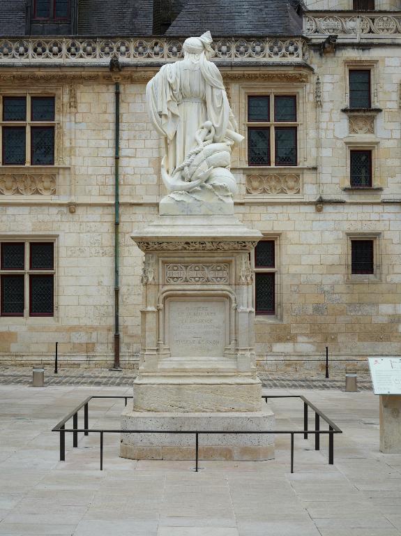 Vue arrière du monument, avec la façade du Palais Jacques Coeur en arrière-plan.