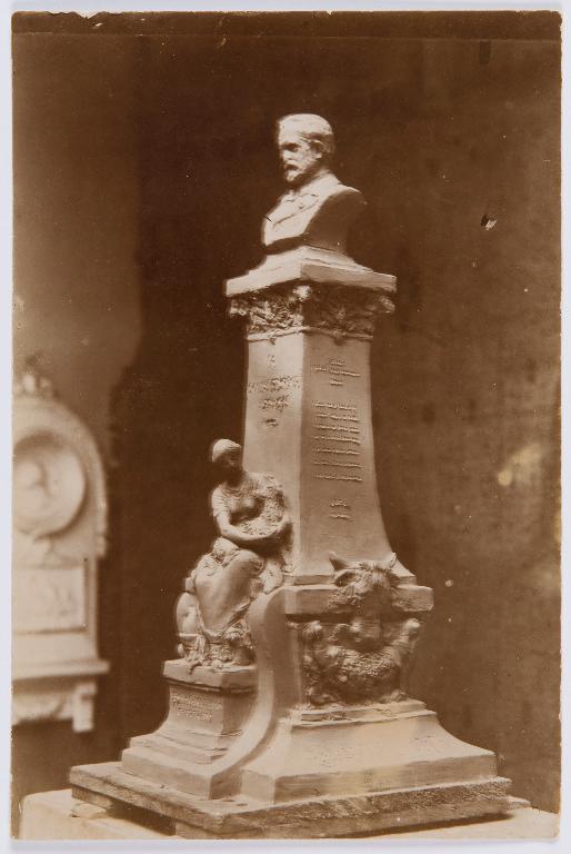 Projet de monument à Pasteur n°2 : photographie ancienne d'une maquette dans l'atelier du sculpteur avec buste sur socle haut, orné d'une figure féminine portant un mouton dans ses bras. (Archives municipales de Chartres, Ma 8/9).