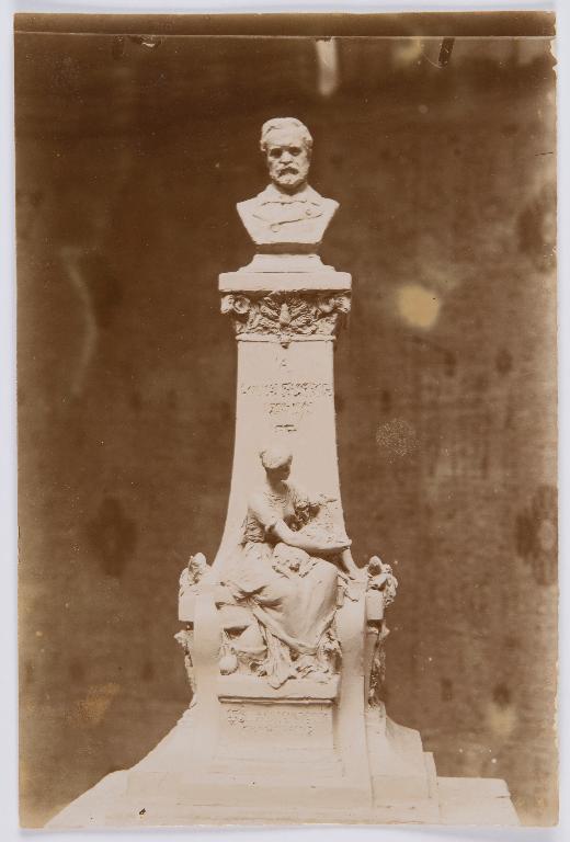 Projet de monument à Pasteur n°2 : photographie ancienne d'une maquette dans l'atelier du sculpteur avec buste sur socle haut orné d'une figure féminine portant un mouton dans ses bras. (Archives municipales de Chartres, Ma 8/9).