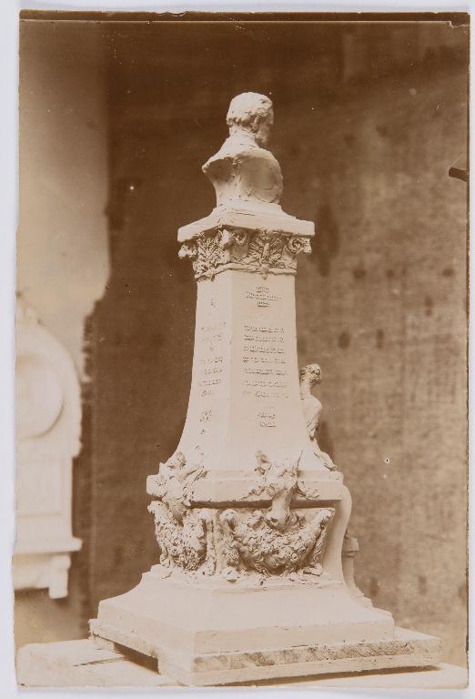 Projet de monument à Pasteur n°2 : photographie ancienne d'une maquette dans l'atelier du sculpteur avec buste sur socle haut orné d'une figure féminine portant un mouton dans ses bras. (Archives municipales de Chartres, Ma 8/9).