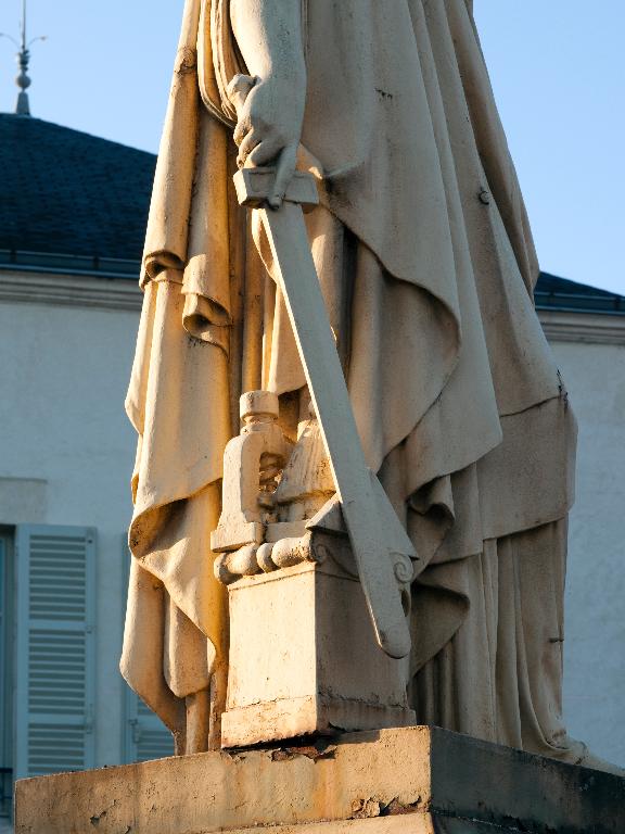 Détail des attributs du côté droit de la statue (triangle de l'égalité, ruche, presse d'imprimerie et épée).