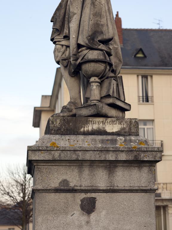 Détail du profil gauche de la statue avec signature sur la plinthe.