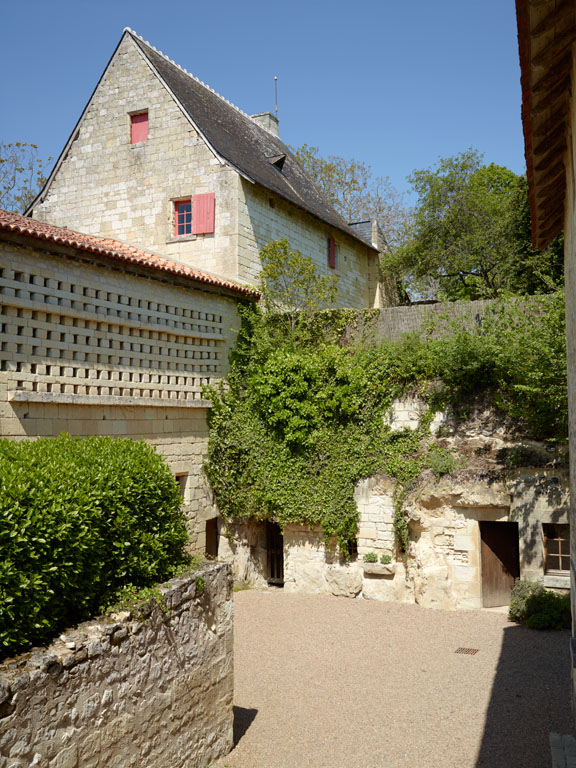 Vue du pigeonnier et du pignon du logis à l'arrière plan, prise depuis les caves demeurantes en contrebas.