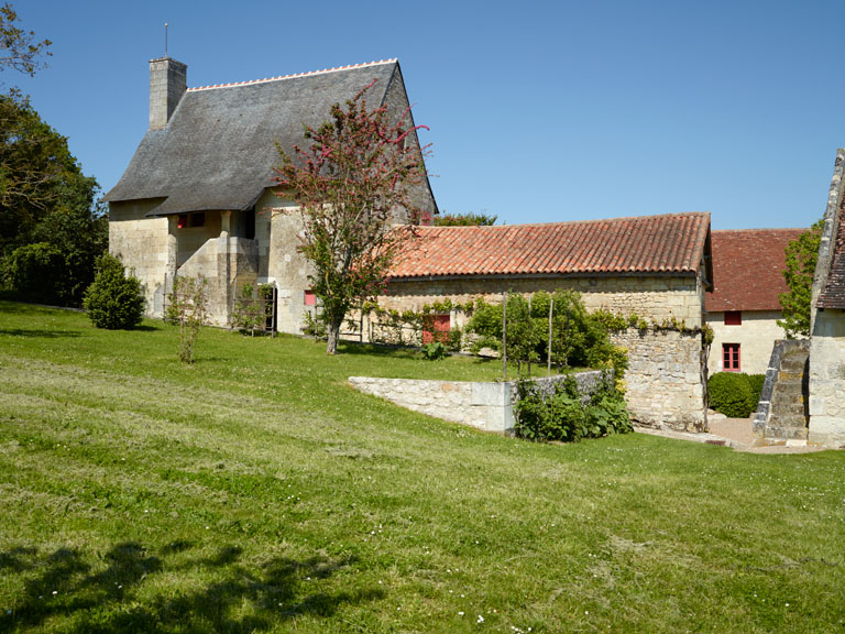 Vue d'ensemble de la façade antérieure du logis et maisons en contrebas.