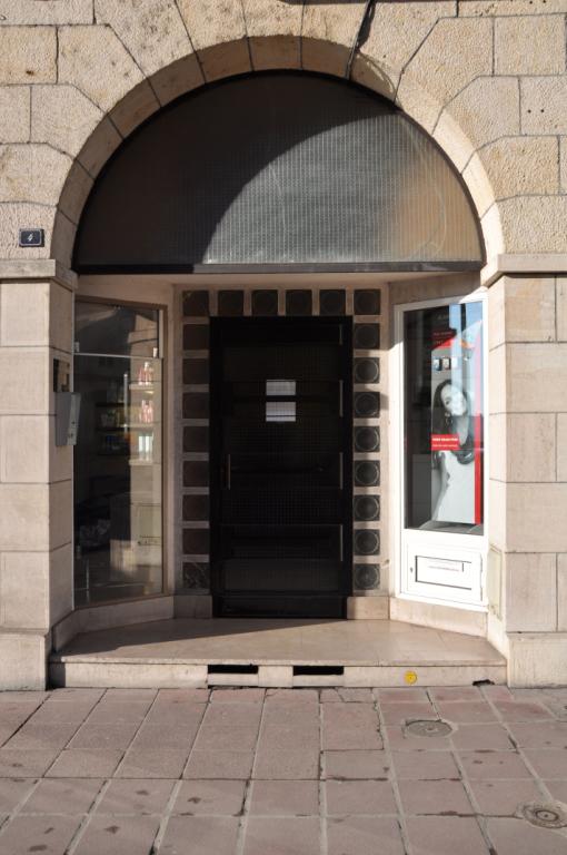 Exemple de porte au fond d'un porche dans oeuvre ouvert sur des vitrines, 4 rue Denis-Papin.