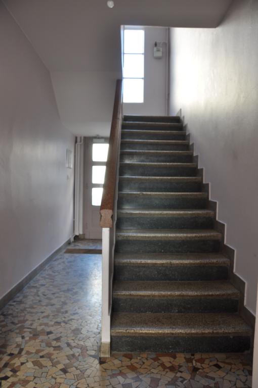 Exemple d'escalier avec revêtement en granito noir, beige et rouge, 6 rue du Premier-Septembre. ; Entrée de l'immeuble : sol en carreau cassé et escalier à revêtement en granito noir, beige et rouge.