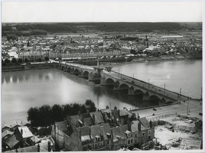 La ville en cours de reconstruction, vue depuis la cathédrale, 1951. On aperçoit les baraquements sur les quais de la rive gauche, devant l'îlot P. (Collection particulière). ; La ville en cours de reconstruction, vue depuis la cathédrale, 1951. Les quelques immeubles condamnés pour la construction de l'îlot K ne sont pas encore détruits. (Collection particulière). ; La ville en cours de reconstruction, vue depuis la cathédrale, 1951. On aperçoit les baraquements sur les quais de la rive gauche. (Collection particulière).