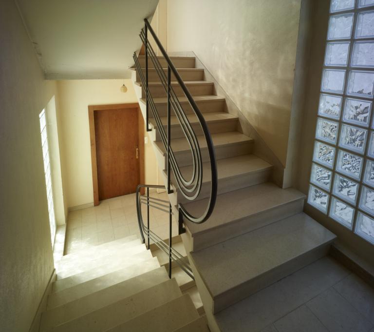 L'escalier qui distribue l'immeuble est éclairé par deux hautes baies de pavés de verre.