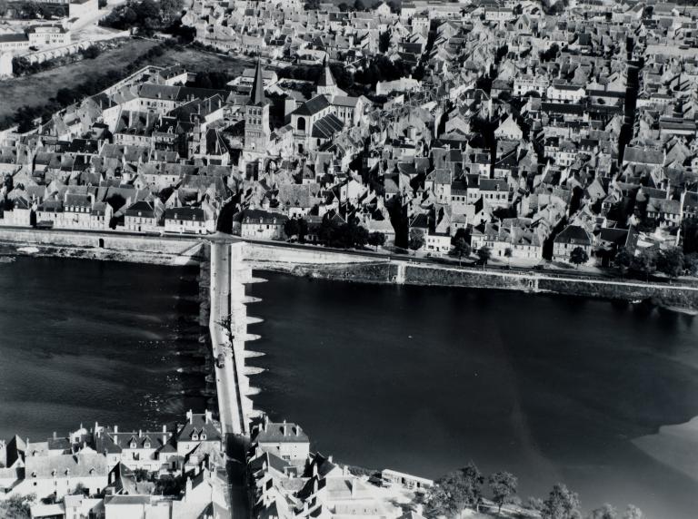 L'île (premier plan), le pont de pierre et la rive droite. Photographie aérienne du milieu du XXe siècle. (archives départementales de la Nièvre, 2 Fi La Charité 163). ; L'île (premier plan), le pont de pierre et les quais de la rive droite. Photographie aérienne du milieu du XXe siècle. (archives départementales de la Nièvre, 2 Fi La Charité 163).