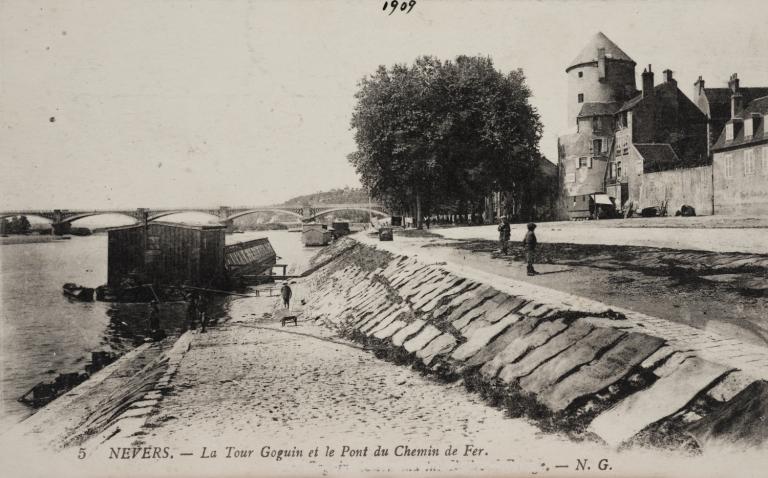 La rampe aval de la cale double située sur le quai de Loire (en aval du pont de Loire). Vue prise vers l'aval. Le perré haut est recouvert de linge mis à sécher. Carte postale ancienne. (archives municipales de Nevers, 5 Fi 2473).