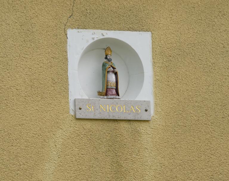 Maison située rue de la Madeleine : statue en céramique polychrome de Saint Nicolas placée dans la niche de la façade. Une inscription est  gravée sur le linteau de porte de cette maison : deux ancres croisées, des initiales (DG) et une date (1838).