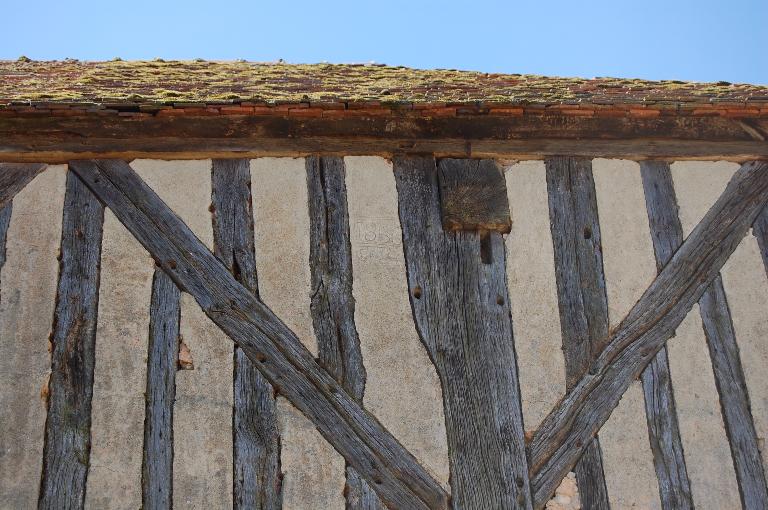 Ancienne halle (betteraverie), vue de détail de l’inscription. ; Chevilleau, mise en oeuvre en pan de bois.