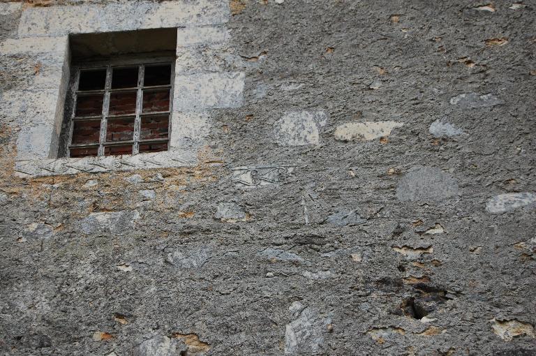 Élévation nord, détail de pierres scuptées remployées dans le mur obstruant le passage vers l'ancien transept détruit.