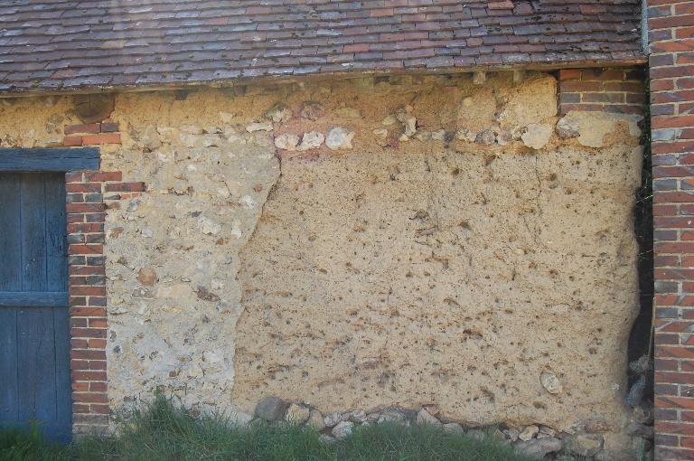 Mise en oeuvre de la terre crue sur solin maçonné en silex à la Chambrie.