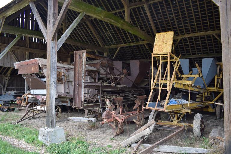 Machines agricoles des années 1950 conservées sous le hangar, vue d'ensemble.