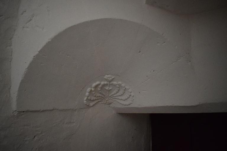 Logis-porte, intérieur, cul-de-lampe orné d'un décor floral (rose) en bas-relief.