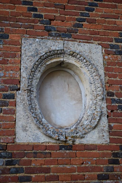 Vue de détail d'un oeil-de-boeuf sculpté d'un décor Renaissance (oves).