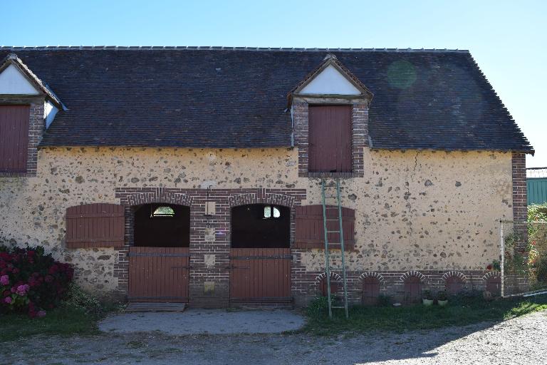 Bâtiment secondaire, partie ouest, vue de détail de la façade nord (portes jumelées, niches à chiens et lucarne au linteau daté).