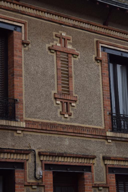 Vue de détail du décor en brique, en façade sur rue.