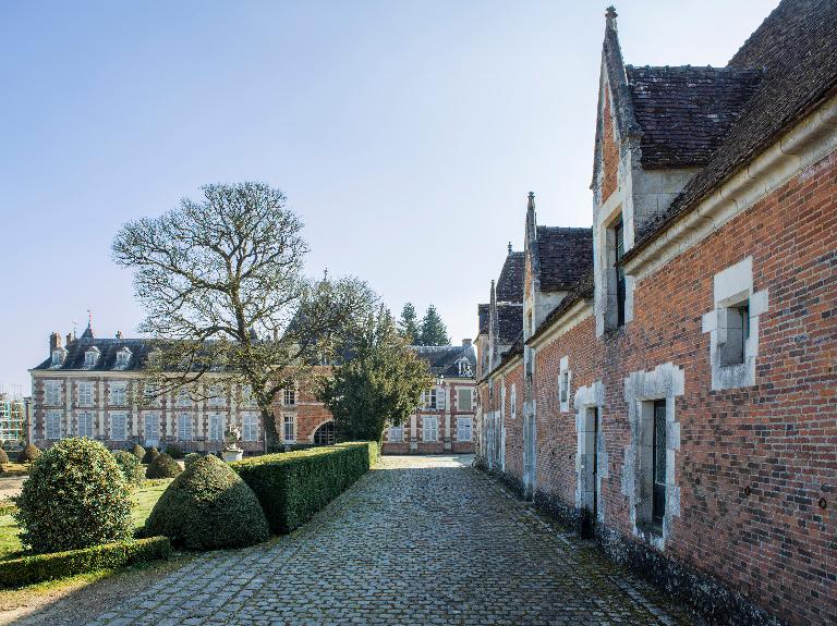 Communs, sol pavé et pavillon du bourg en arrière plan, vue générale depuis l'ouest.