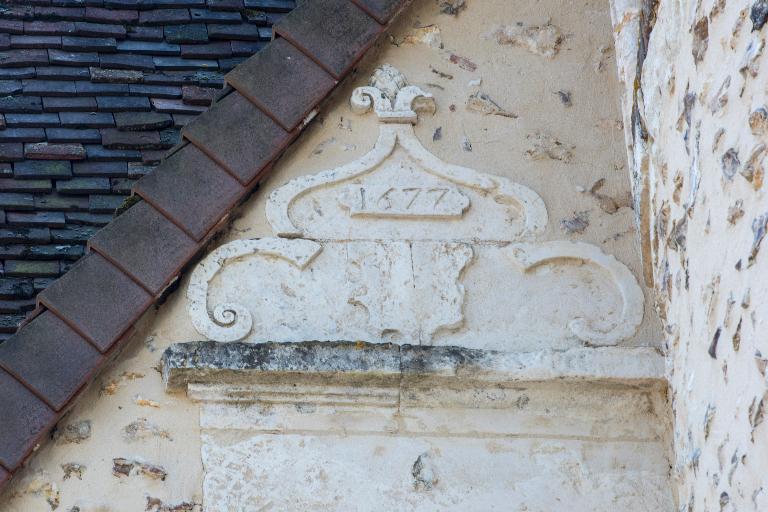 Élévation nord-ouest, vue de détail des ornements, du blason et de la date 1677 portée au-dessus du linteau d'une fenêtre de l'étage de comble.