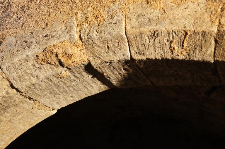 Vue intérieure, rez-de-chaussée, cave, détail de l'arc de la cellule centrale, mur sud.