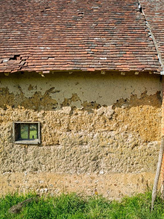 Ferme n°7, façade nord, vue de détail de la mise en oeuvre en terre crue.