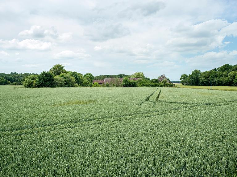 Le Charmois, ferme en "U" ; Vue éloignée de la ferme depuis l'est.