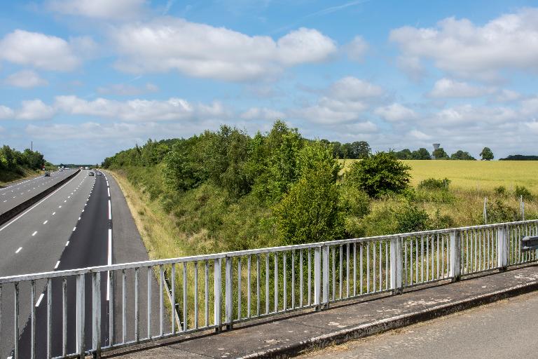 Autoroute A11 et château d'eau (en arrière-plan à droite) vus depuis la départementale D124 à l'est de la commune à proximité du Petit Ézanville.