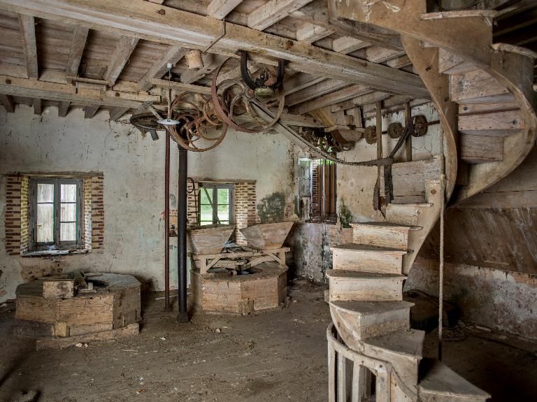 Bâtiment principal, partie atelier, meules et trémies du rez-de-chaussée surélevé. ; Moulin de Gaillard : meules, trémies et escalier.