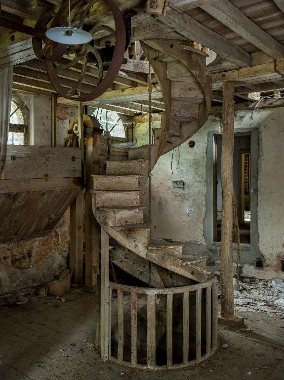 Bâtiment principal, partie atelier, rez-de-chaussée surélevé, vue de l’escalier à vis en bois, suspendu et sans mur de cage.