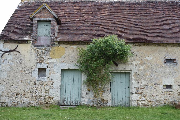 Bâtiment principal, vue de détail des ouvertures des dépendances. ; La Bigotière : mise en oeuvre en moellons de calcaire et de silex, encadrement d'ouvertures et chaînes d'angle en pierre de taille calcaire, lucarne en brique.