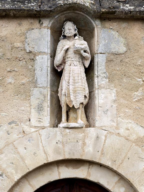 Statue de saint Jean-Baptiste surmontant le portail de la tour-clocher.