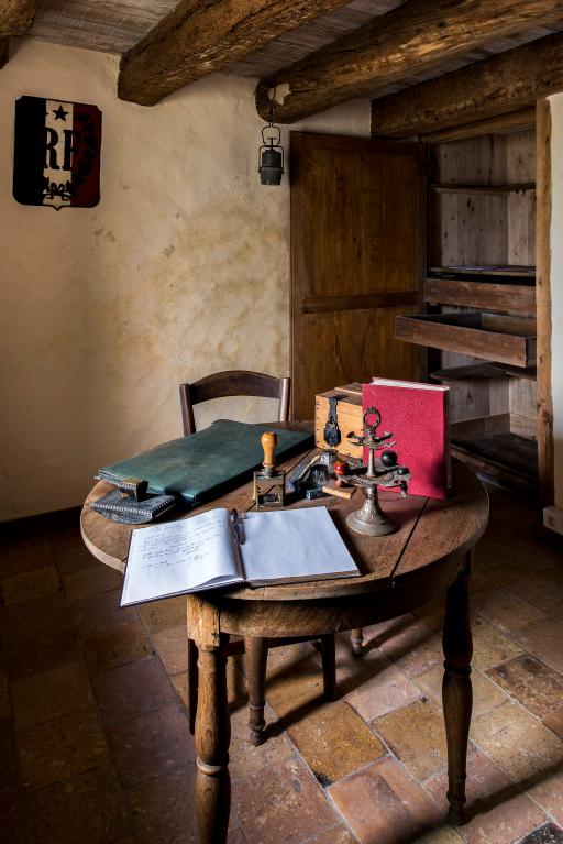 Deuxième étage de la tour-clocher, vue d'ensemble de la table et du placard mural disposant de grands titoirs pour le cadastre ancien.