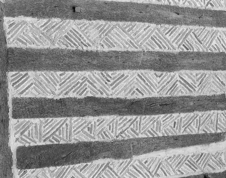 Détail du pan de bois à remplissage de tuile plate.