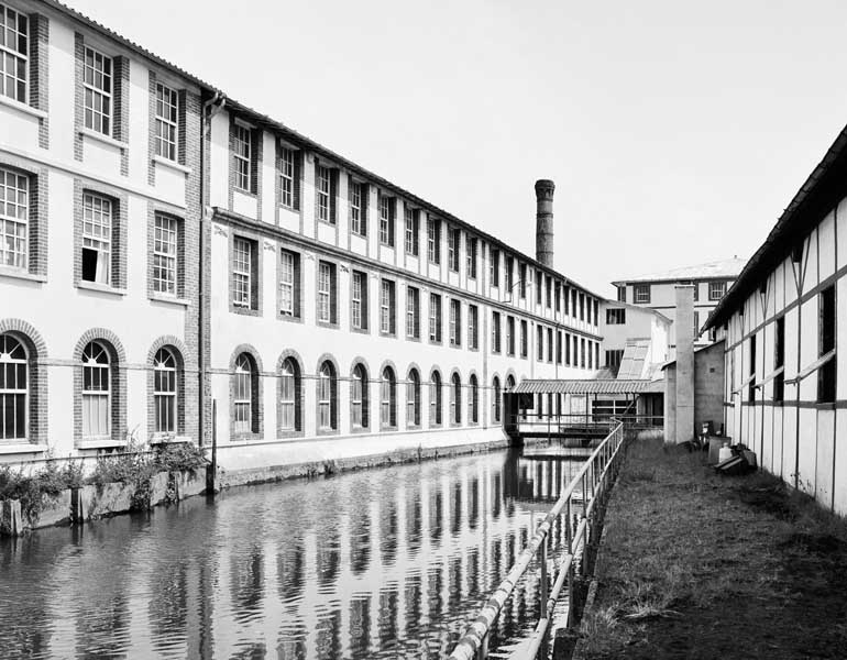 Saint-Sulpice-sur-Risle, usine de quincaillerie, tréfilerie dite Etablissements Bohin : atelier de fabrication et canal. ; Atelier de fabrication (1) et canal, vue prise du sud ouest.