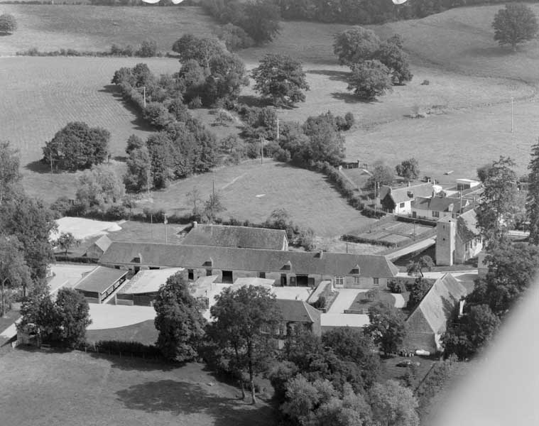 Vue aérienne prise du sud ouest. A gauche, la ferme du pin, au centre l'ancienne église paroissiale Saint-Ouen, à droite l'ancien presbytère.
