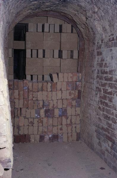 Four continu à galeries, détail : enfournement des briques : Cuisson des briques. Fermeture d'une porte du four.