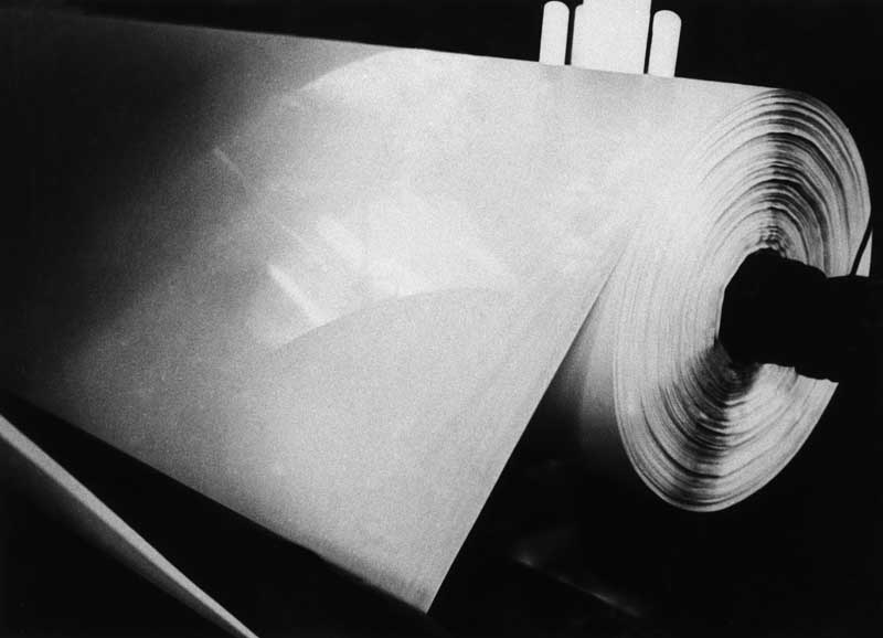Après sécherie à vapeur, le papier terminé s'enroule majestueusement sur la bobine.- Photographie ancienne. (Collection particulière).