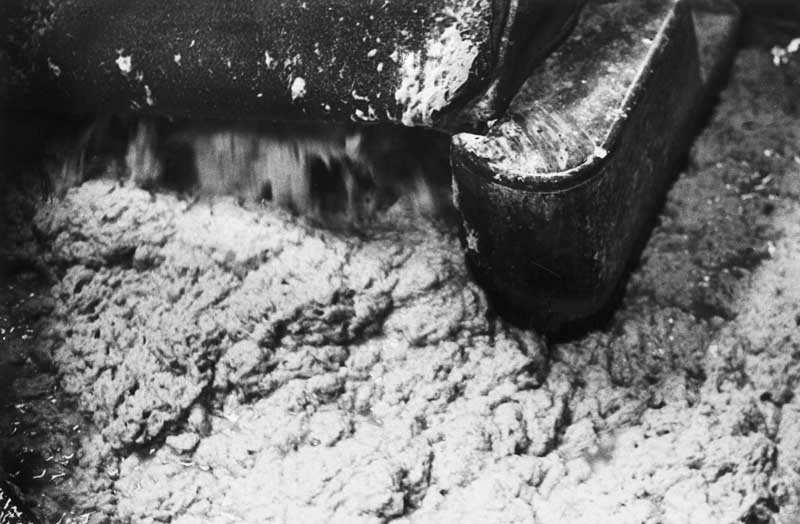 La pâte s'écoule en mousse projetée par la rotation du cylindre.- Photographie ancienne. (Collection particulière).