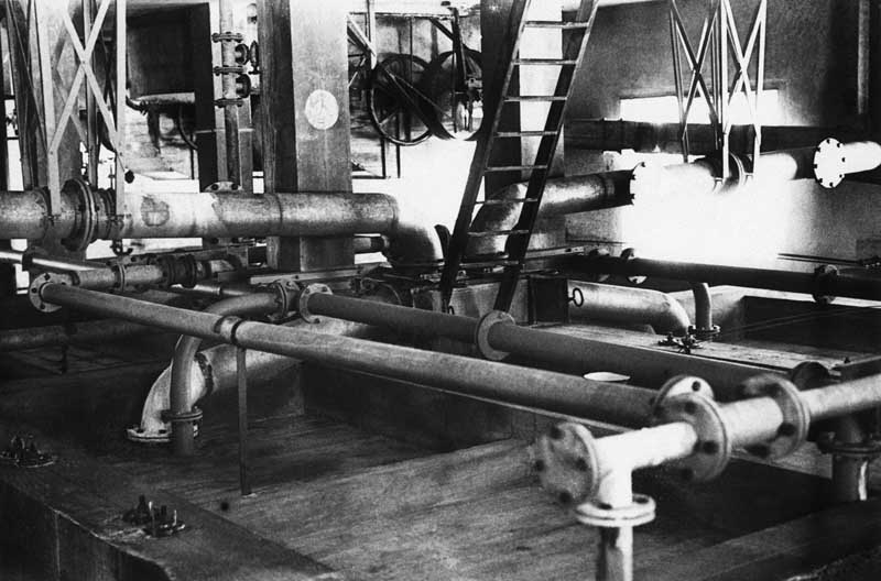 Tuyauterie assurant le transport des chiffons-pâte, des produits chimiques, de l'eau, destinés aux piles blanchisseuses.- Photographie ancienne. (Collection particulière).