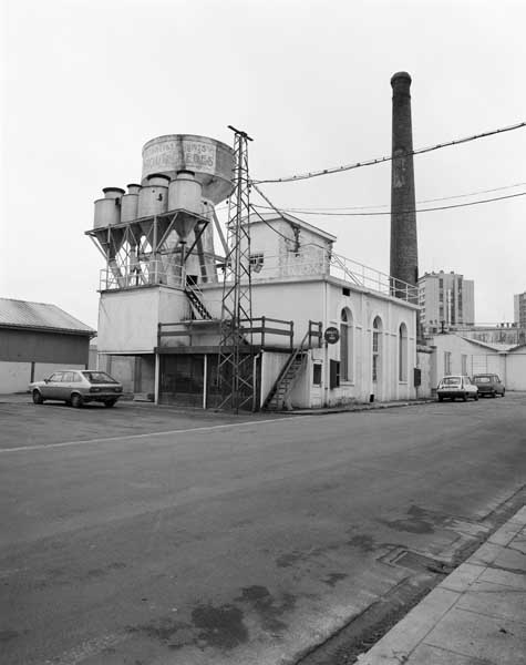 Salle des machines, cheminée d'usine et château d'eau. Vue prise du nord ouest.