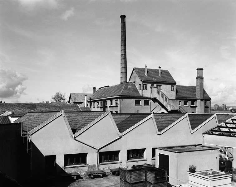 Ateliers de fabrication (au 1er plan), cantine et cheminée d'usine. Vue prise du sud-est.