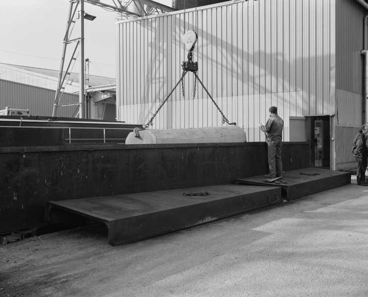 Sortie d'une bille de bois hors d'une étuve.