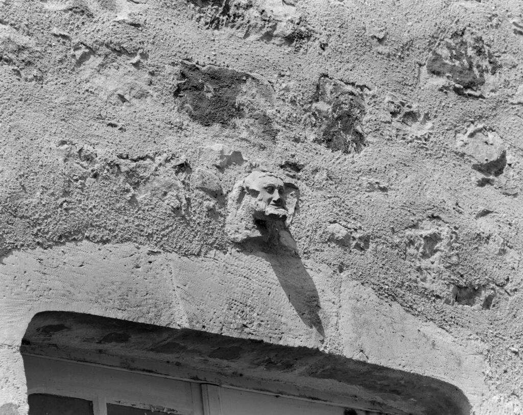Tour dite "Tour du chartrier". Sculpture en remploi représentant un visage humain.