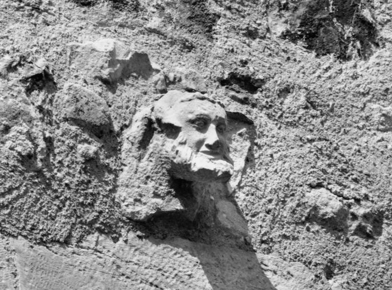 Tour dite "Tour du chartrier". Détail d'une sculpture en remploi représentant un visage humain.