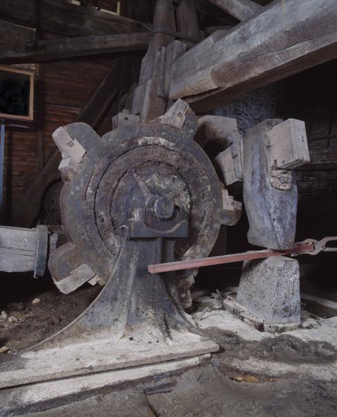 Atelier de fabrication, vue intérieure : marteau hydraulique. Détail : arbre à cames et tête du marteau.