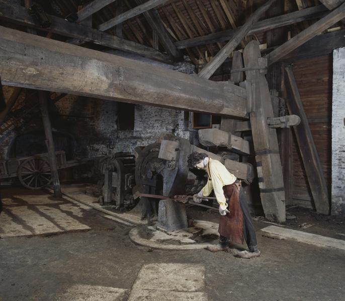 Atelier de fabrication, vue intérieure : le marteau hydraulique (ressort, drôme) et sa charpente.