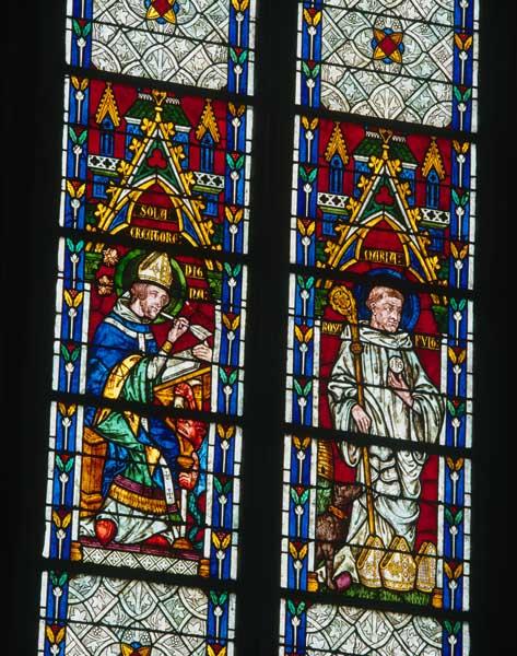 Détail des deux lancettes de la baie 1, registres 4, 5 et 6 : un saint évêque écrivant à sa table et un saint abbé accompagné d'un chien et de trois mitres à ses pieds.