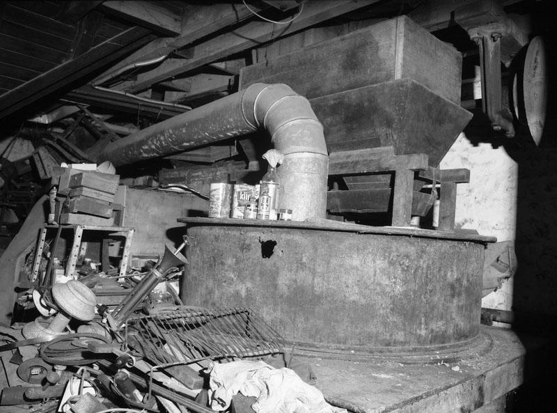 Atelier de fabrication. Vue intérieure. Détail : meule et trémie.